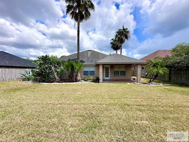 rear view of property featuring a lawn