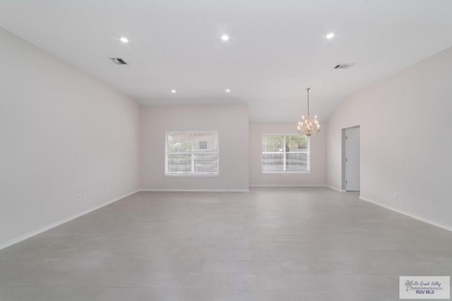 spare room featuring a chandelier and lofted ceiling