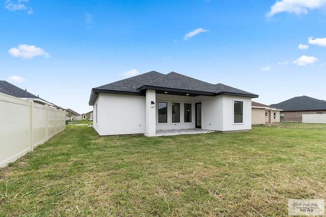 rear view of house with a patio and a lawn