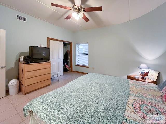 bedroom featuring ceiling fan, light tile patterned floors, and a closet