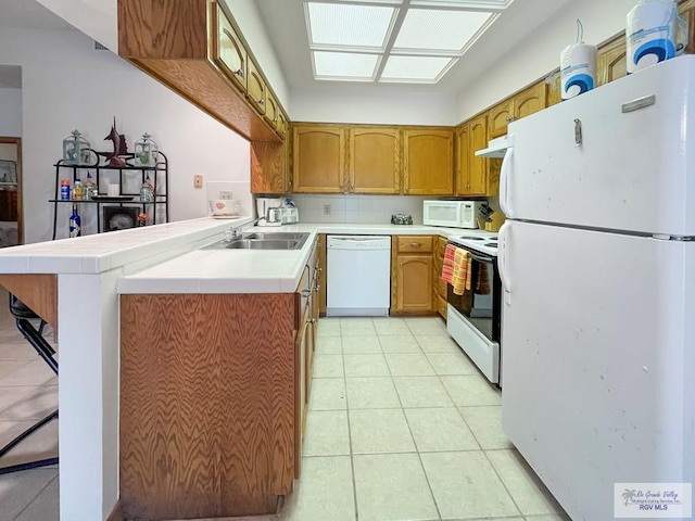 kitchen with white appliances, tile counters, sink, kitchen peninsula, and light tile patterned floors