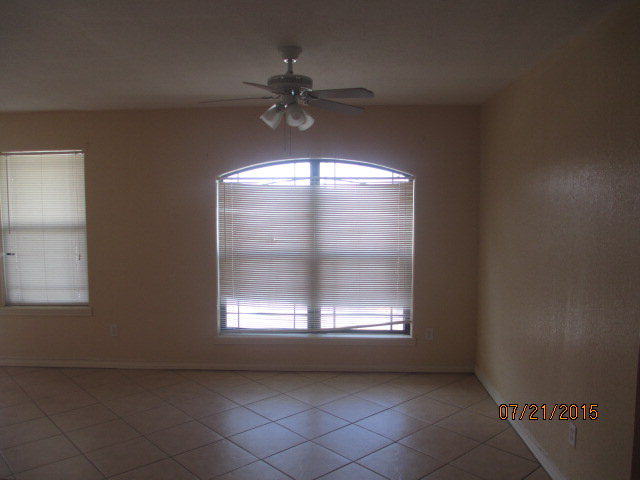 spare room featuring tile patterned floors, plenty of natural light, and ceiling fan