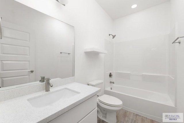 full bathroom featuring hardwood / wood-style flooring, vanity, toilet, and washtub / shower combination