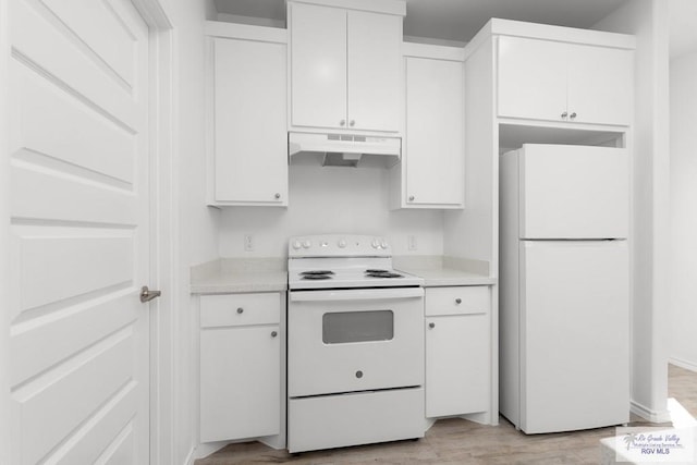 kitchen with white cabinets, light wood-type flooring, and white appliances