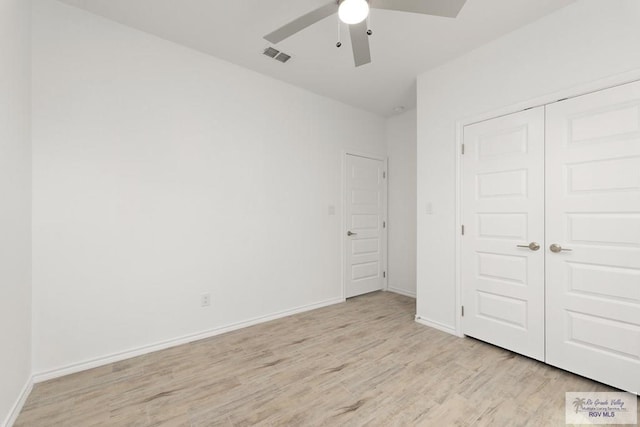 unfurnished bedroom featuring ceiling fan, a closet, and light hardwood / wood-style flooring