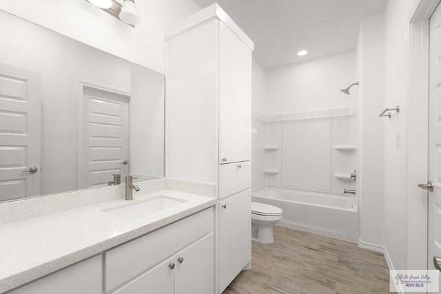 full bathroom featuring bathtub / shower combination, wood-type flooring, vanity, and toilet