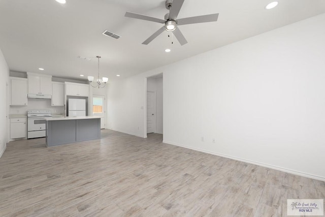 kitchen with white cabinetry, a center island, hanging light fixtures, light hardwood / wood-style flooring, and white appliances