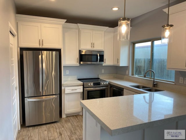 kitchen featuring white cabinets, decorative light fixtures, kitchen peninsula, and stainless steel appliances