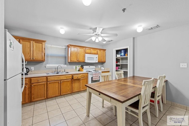 kitchen featuring ceiling fan, sink, light tile patterned floors, and white appliances