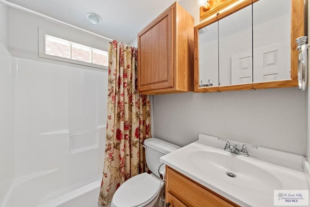 full bathroom featuring shower / bath combo with shower curtain, vanity, and toilet