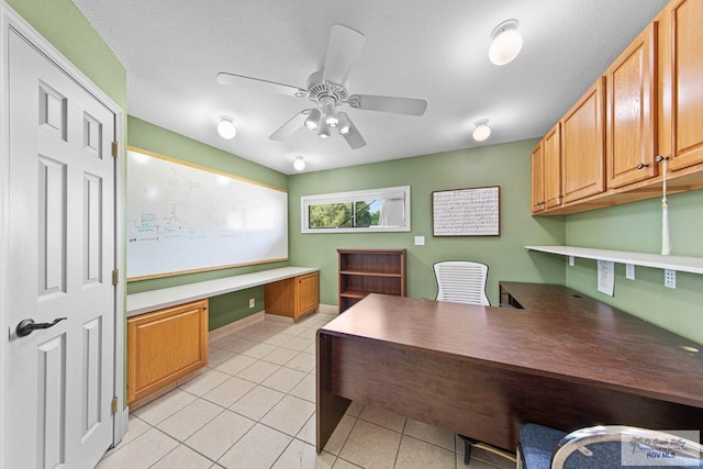 office area with ceiling fan, light tile patterned floors, and built in desk