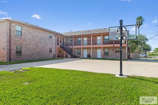 view of sport court featuring a yard