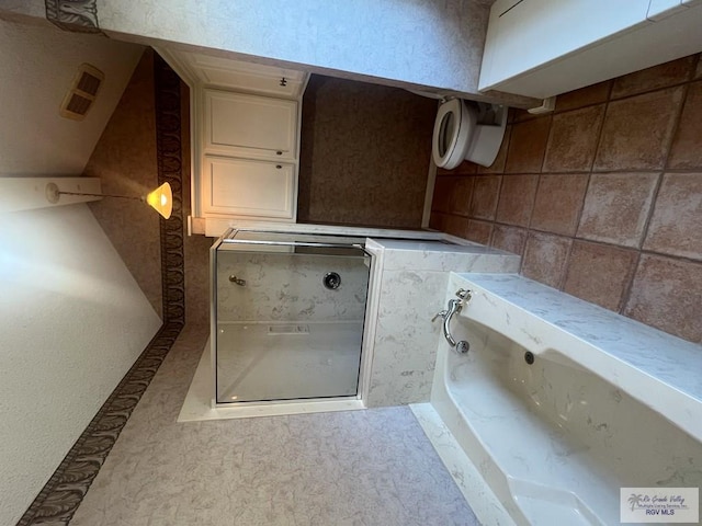 bathroom with visible vents and a bath
