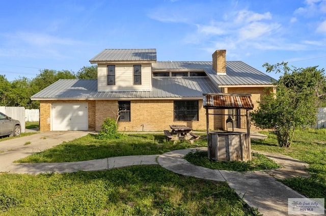 3401 Del Mar Dr, Mission, TX 78574 - view of front of home with metal roof, concrete driveway, a chimney, and brick siding