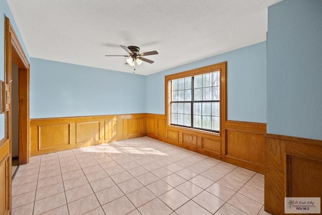 3401 Del Mar Dr, Mission, TX 78574 - spare room featuring light tile patterned flooring, a wainscoted wall, and a ceiling fan