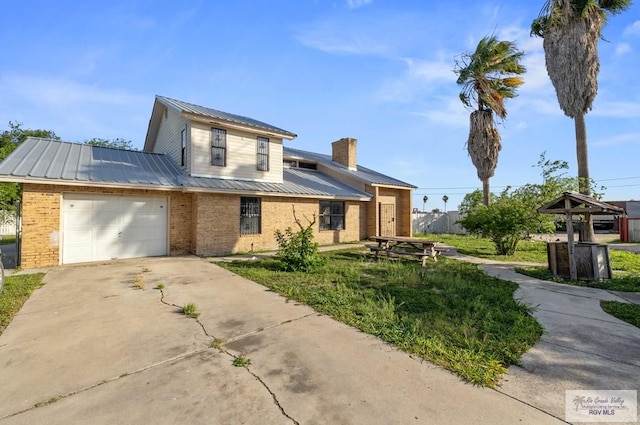 3401 Del Mar Dr, Mission, TX 78574 - view of front of property featuring metal roof, an attached garage, brick siding, and driveway
