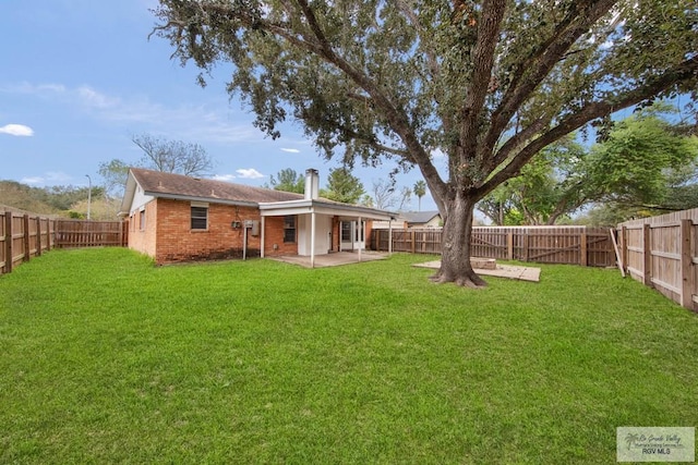 1722 High St, Harlingen, TX 78550 - back of property featuring a yard, a fenced backyard, brick siding, and a patio
