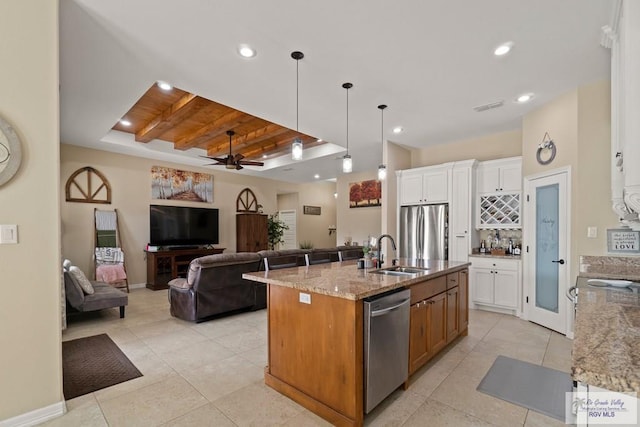 kitchen featuring sink, white cabinets, a kitchen island with sink, light stone counters, and stainless steel appliances