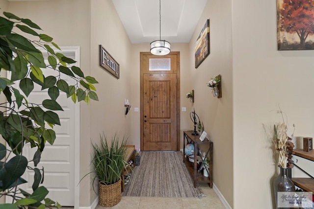 interior space featuring light tile patterned flooring and a tray ceiling