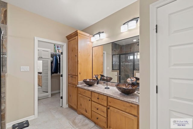 bathroom with tile patterned floors, vanity, and a shower with shower door