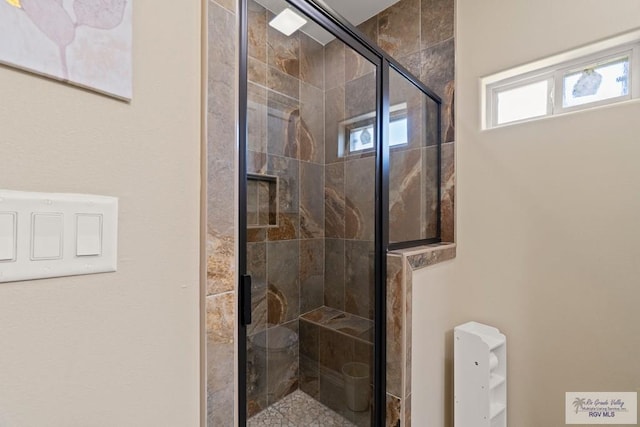 bathroom featuring toilet and a shower with shower door