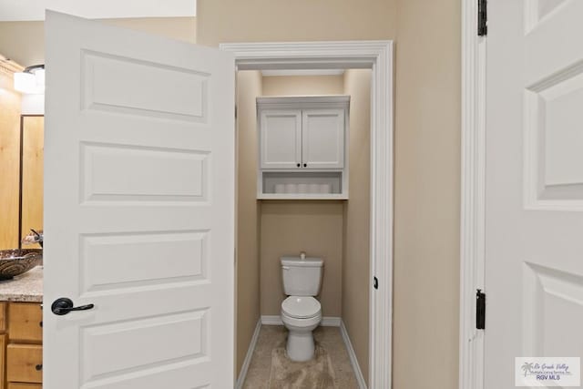 bathroom featuring tile patterned floors, vanity, and toilet