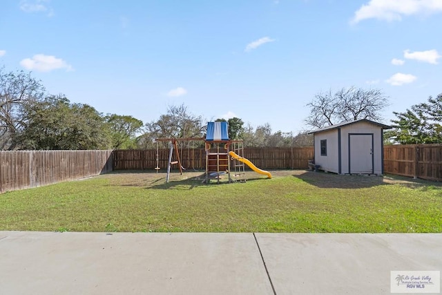 view of playground featuring a lawn and a storage unit