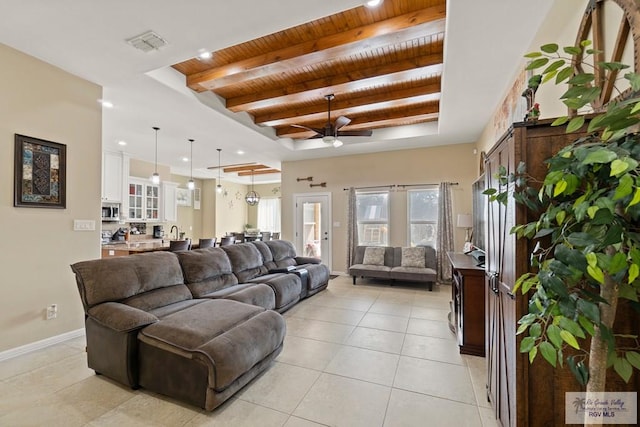 living room featuring wood ceiling, light tile patterned floors, a tray ceiling, ceiling fan, and beam ceiling