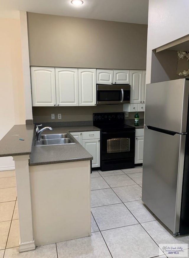 kitchen featuring light tile patterned flooring, sink, appliances with stainless steel finishes, kitchen peninsula, and white cabinets