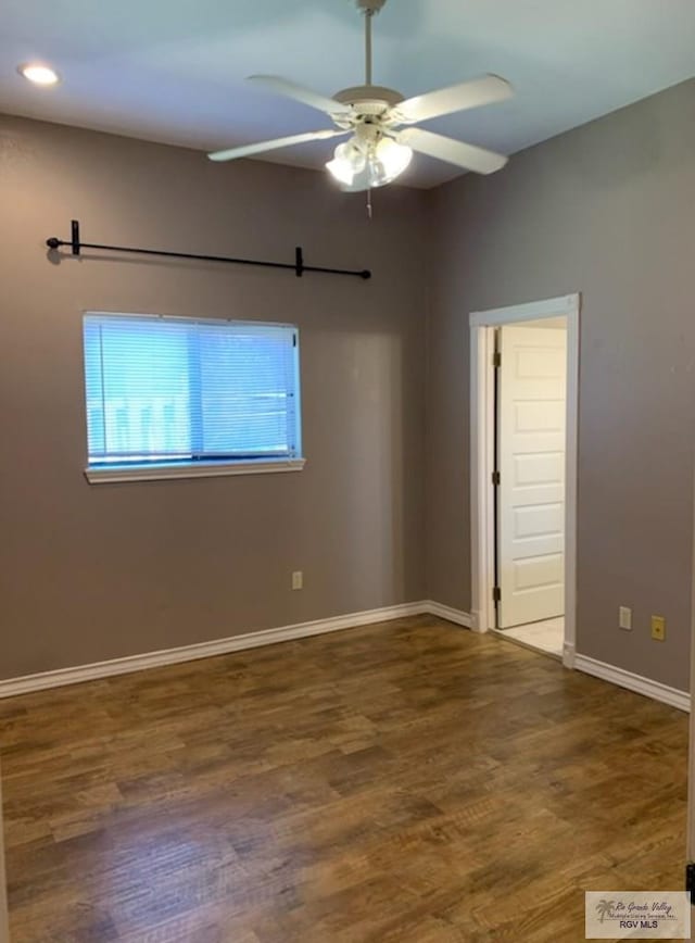 empty room with dark hardwood / wood-style floors and ceiling fan