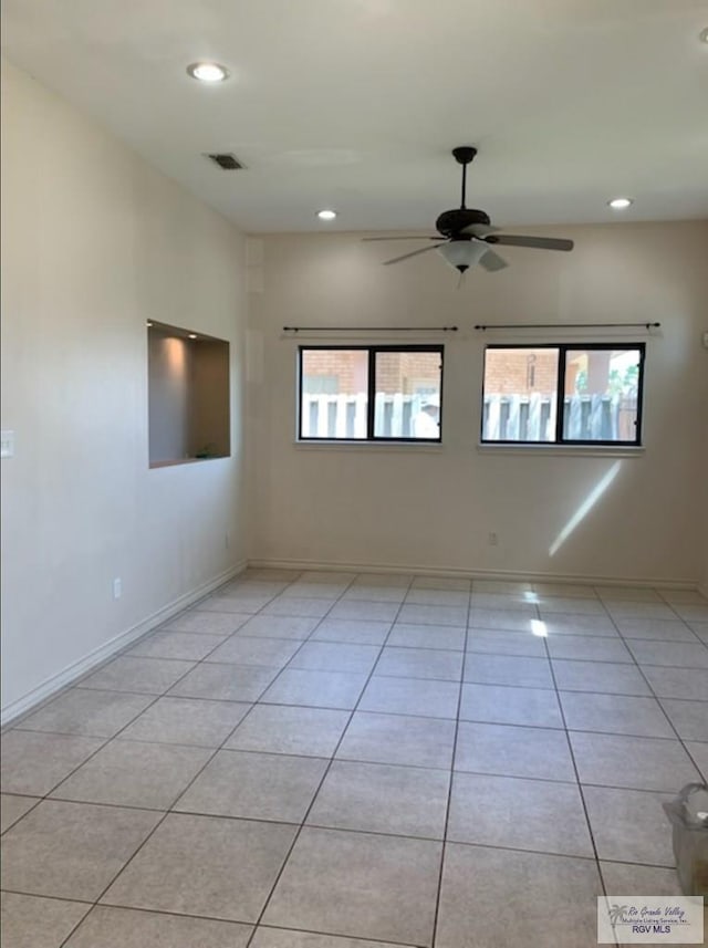 tiled spare room featuring ceiling fan