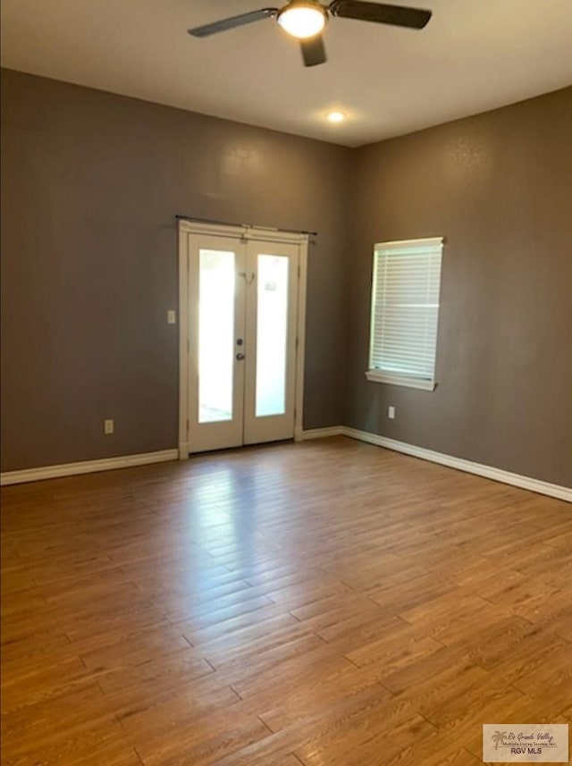 spare room featuring french doors, ceiling fan, and light wood-type flooring