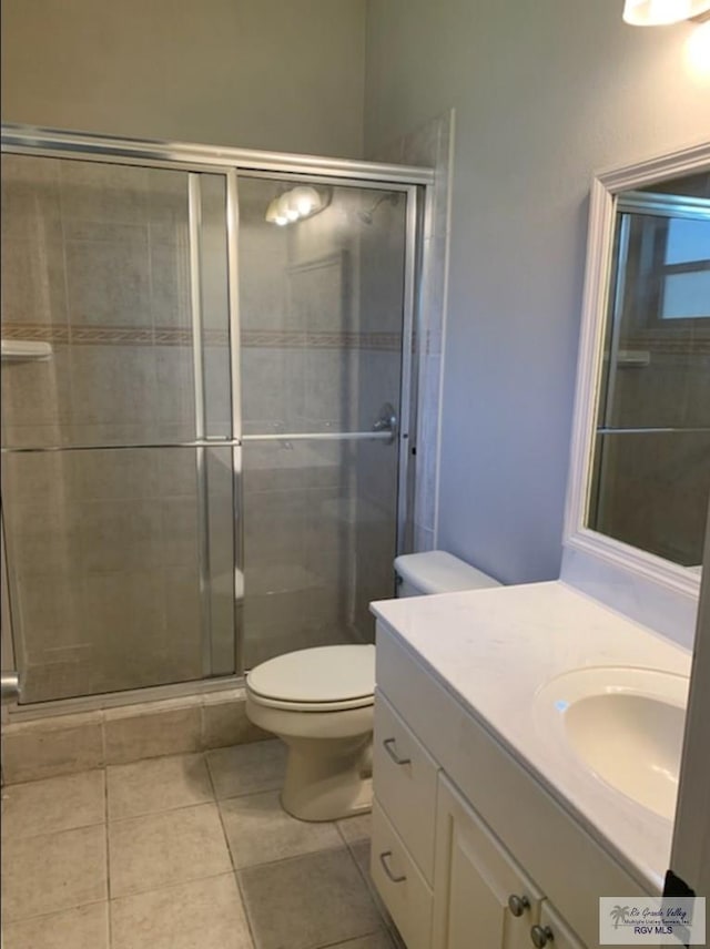 bathroom featuring vanity, tile patterned floors, toilet, and walk in shower