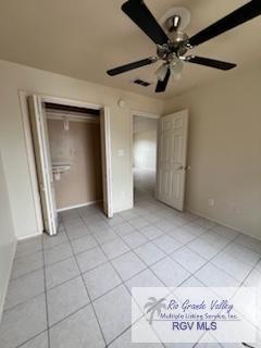 unfurnished bedroom with ceiling fan, a closet, and light tile patterned floors