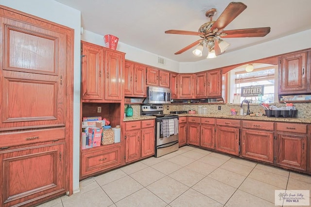 kitchen with brown cabinetry, ceiling fan, stainless steel appliances, and backsplash