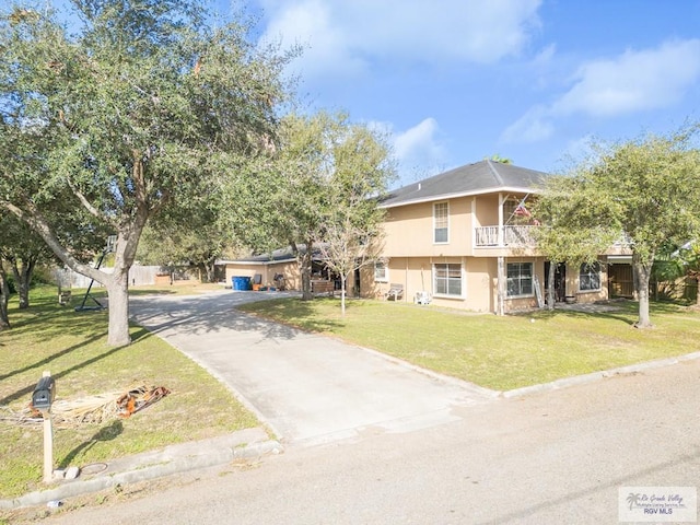 view of front of property with stucco siding, concrete driveway, a balcony, a garage, and a front lawn