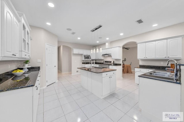 kitchen with pendant lighting, white cabinetry, a kitchen island, and sink