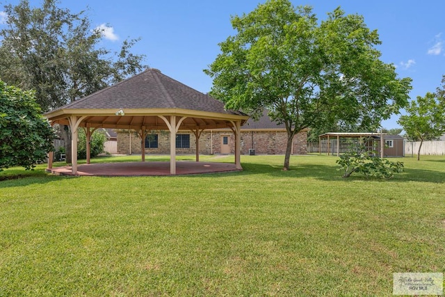 view of community with a gazebo, a lawn, and a storage shed