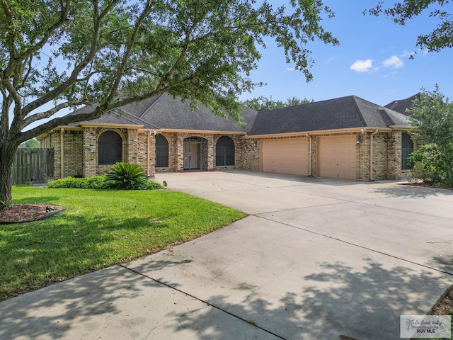 ranch-style home featuring a garage and a front lawn