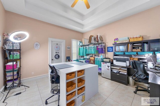 tiled office space featuring ceiling fan and a raised ceiling