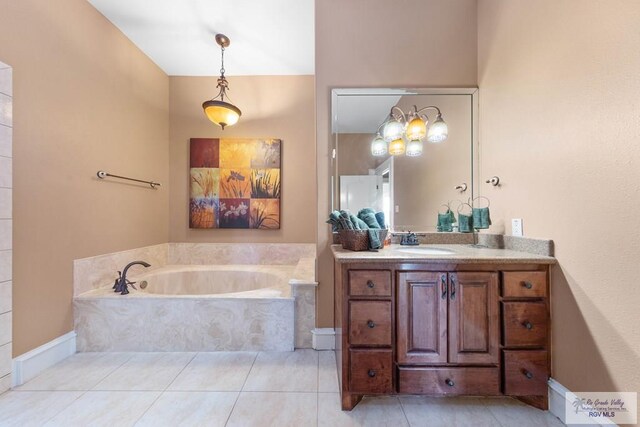 bathroom with tile patterned floors, a relaxing tiled tub, and vanity