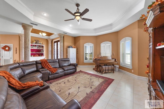 living room featuring decorative columns, a raised ceiling, and a wealth of natural light