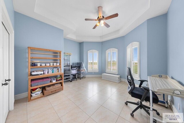 tiled office featuring ceiling fan and a raised ceiling