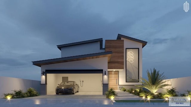 exterior space with concrete driveway, stucco siding, and an attached garage