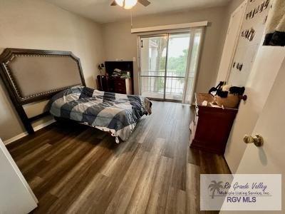 1900 E Elizabeth St Unit F13, Brownsville, TX 78520 - bedroom with access to exterior, wood finished floors, and a ceiling fan