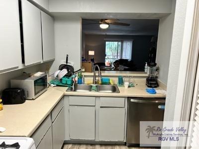 1900 E Elizabeth St Unit F13, Brownsville, TX 78520 - kitchen with stainless steel appliances, light countertops, white cabinets, and a ceiling fan
