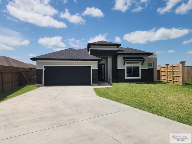 prairie-style home featuring a garage and a front lawn