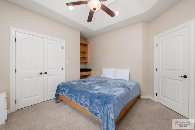 carpeted bedroom with ceiling fan and a closet