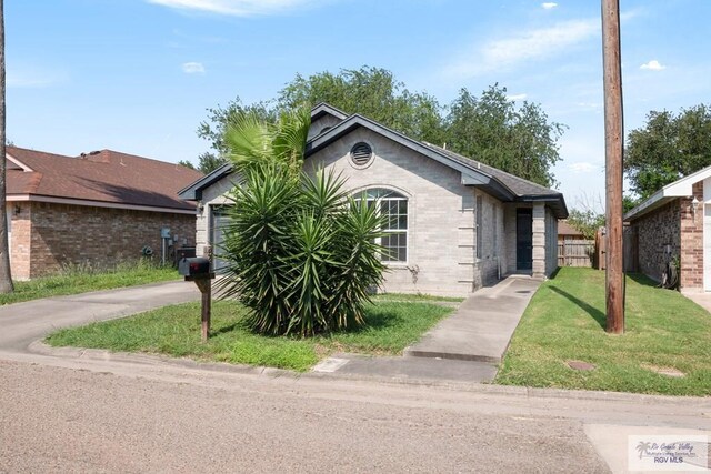 single story home with fence, a front lawn, brick siding, a garage, and concrete driveway
