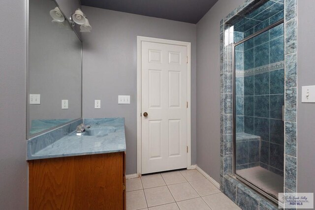 bathroom with tile patterned flooring, baseboards, vanity, and a shower stall